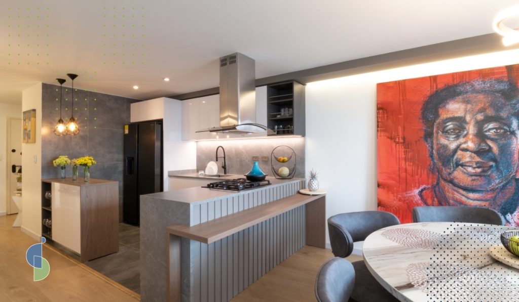 Cocina abierta con península y barra de madera más baja para comer o trabajar sentado