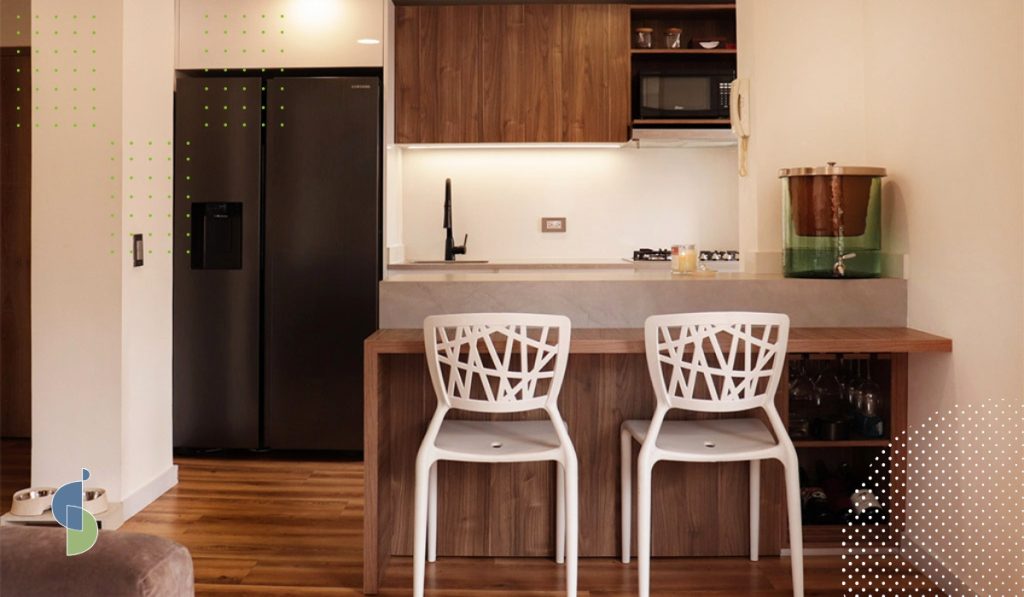 Cocina pequeña de apartamento con barra y luz LED bajo los muebles altos