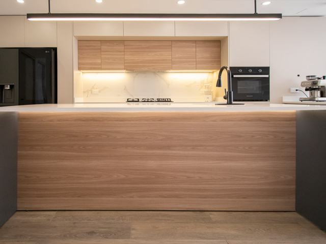 Cocina integral abierta de melamina en tono madera.