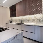 Cocina en tonos beige con mesón de piedra sinterizada y gabinete superior en madera