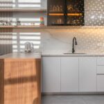 Cocina integral con isla en madera y frentes sin tiradores en tonos cálidos