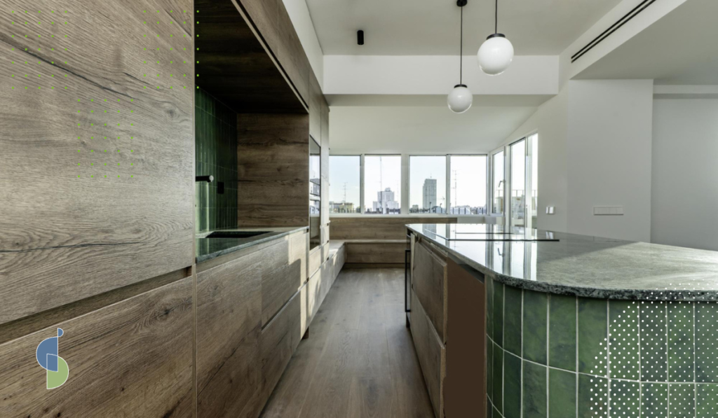 Cocina con isla curva revestida en azulejos verdes y mesón en piedra natural, materiales para diseño orgánico
