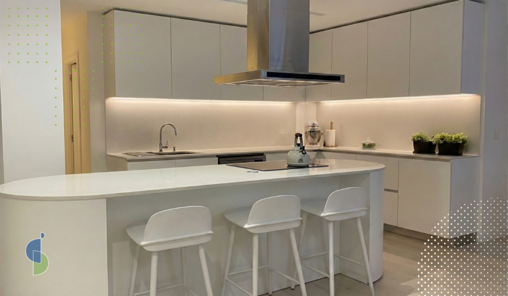  Cocina blanca compacta con isla ovalada redondeada y taburetes, solución para apartamentos pequeños en Bogotá
