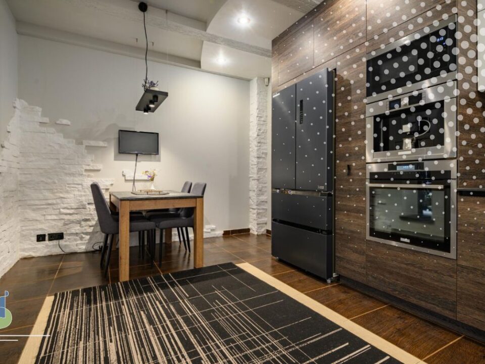 Vista de cocina moderna con torre de electrodomésticos integrados y refrigerador panelado