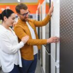 Pareja en Colombia comparando neveras para elegir un electrodoméstico eficiente con etiqueta energética