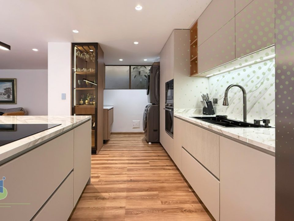Cocina lineal en tonos greige con enchapes en madera y mesón en piedra sinterizada veteada