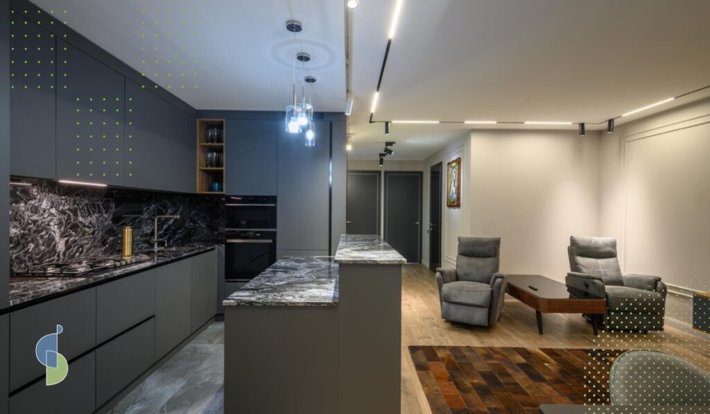 Cocina integral gris antracita sin manijas con isla de mármol oscuro integrada al área social del apartamento