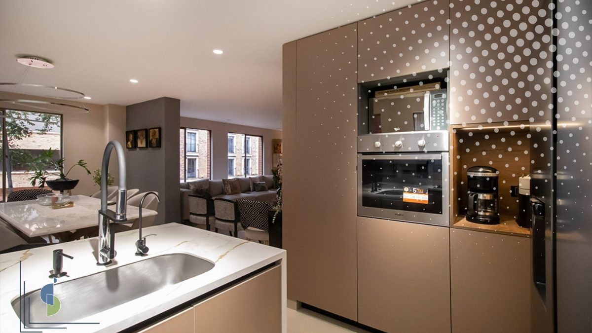 Cocina abierta con isla y lavaplatos conectada al comedor y la sala de un apartamento