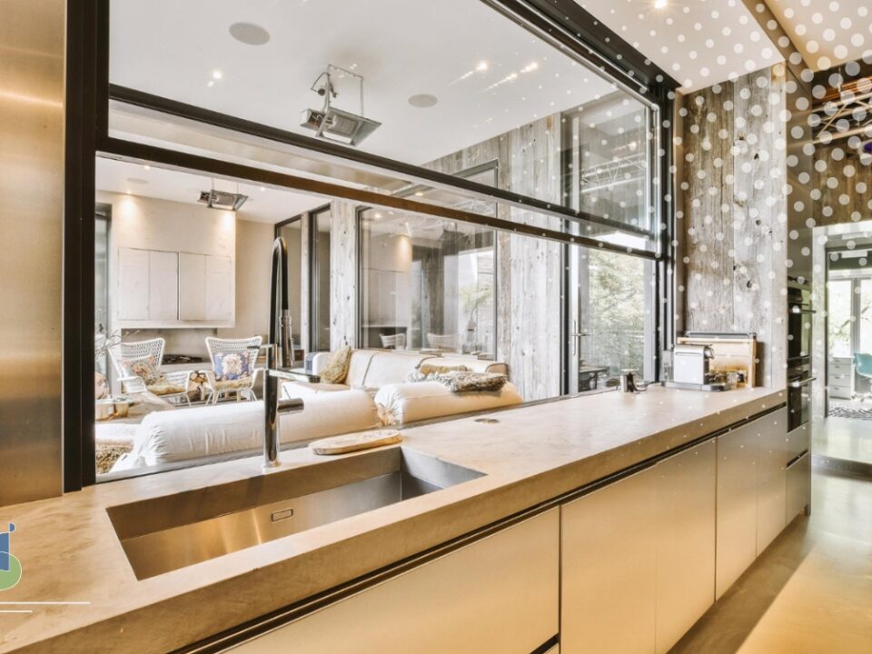 Cocina moderna con cerramiento de vidrio transparente entre sala y área de preparación de alimentos