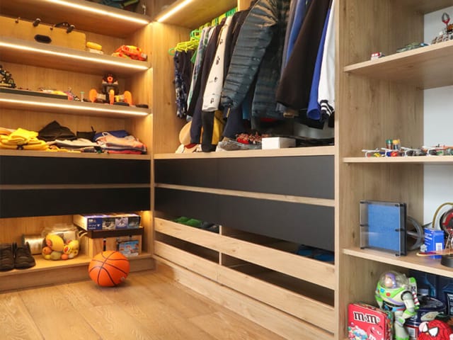 Walk-in closet práctico y elegante con vestidor, colores madera y negro con accesorios y herrajes importados, iluminación LED
