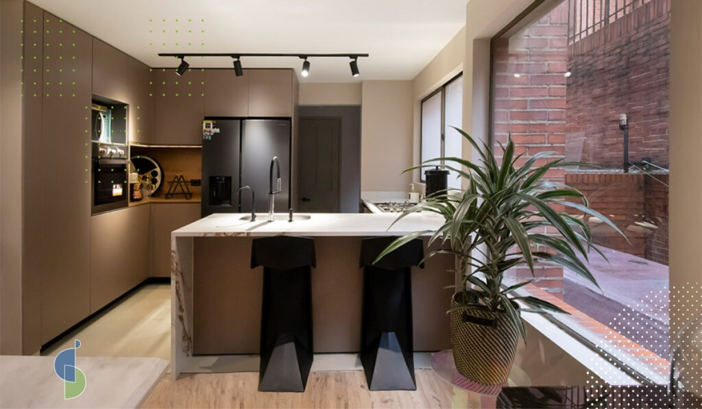 Isla de cocina en madera clara junto a comedor con mesa de madera y sillas negras