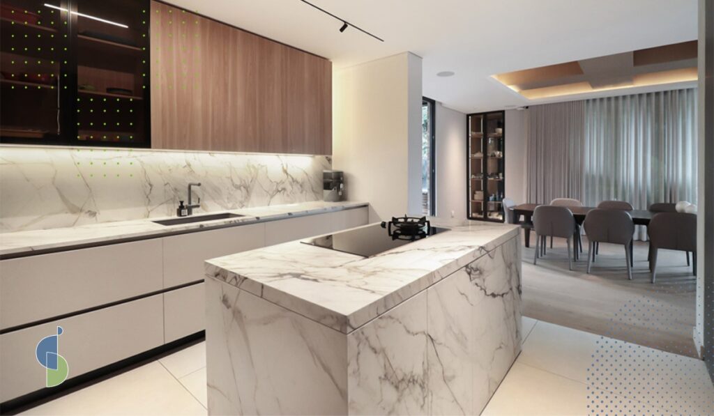 Cocina de lujo con isla en mármol cascada, mueble alto en chapa de madera y comedor al fondo